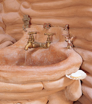 
Gernot’s bathroom is a fluid sculpture made from coils of clay. Every detail was created in mud plaster, from the legs of the sink to the actual basin—a completely waterproof and practical design. Gernot’s clay sink was made using a high sandy loam with 6 percent linseed oil for repelling water, then coated with a layer of linseed oil. After eleven years, the basin shows little if any signs of deteriorating.
